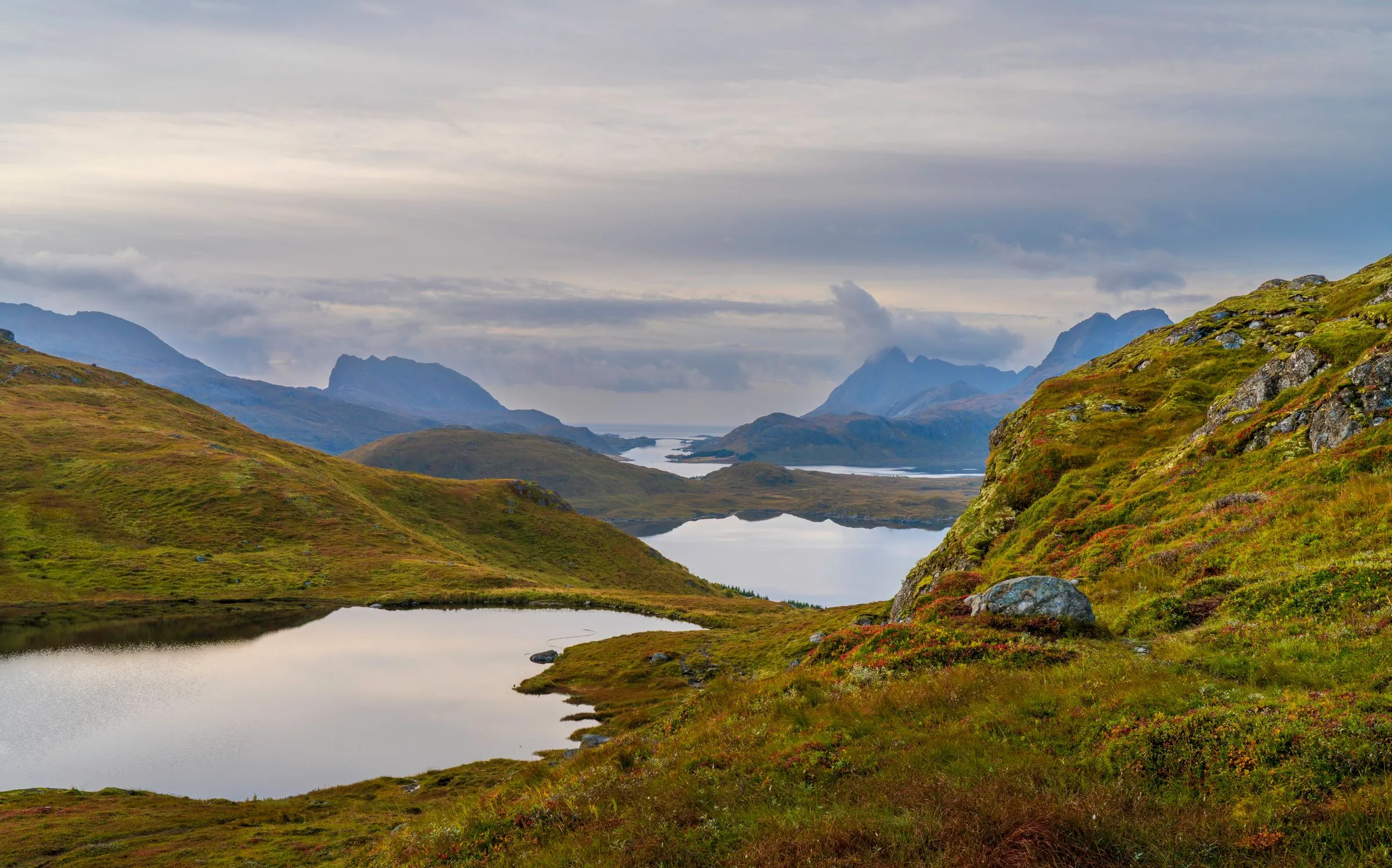 Autumn tundra and small mountain lakes opening toward distant jagged peaks.